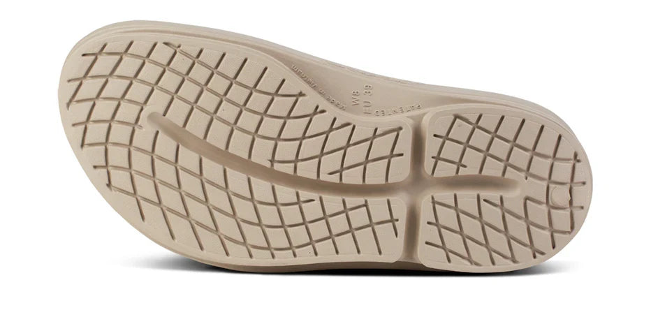 Women's OOFOS OOmega OOahh Slide in Nomad. Tan. Bottom view.