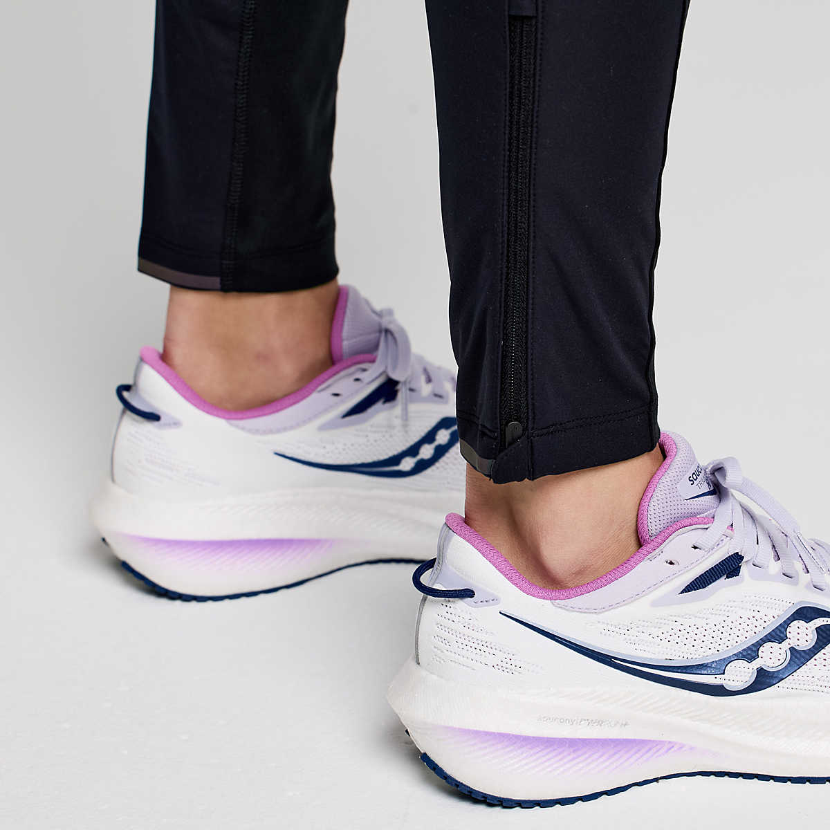 Women's Saucony RunShield Tights. Black. Ankle zipper closeup.