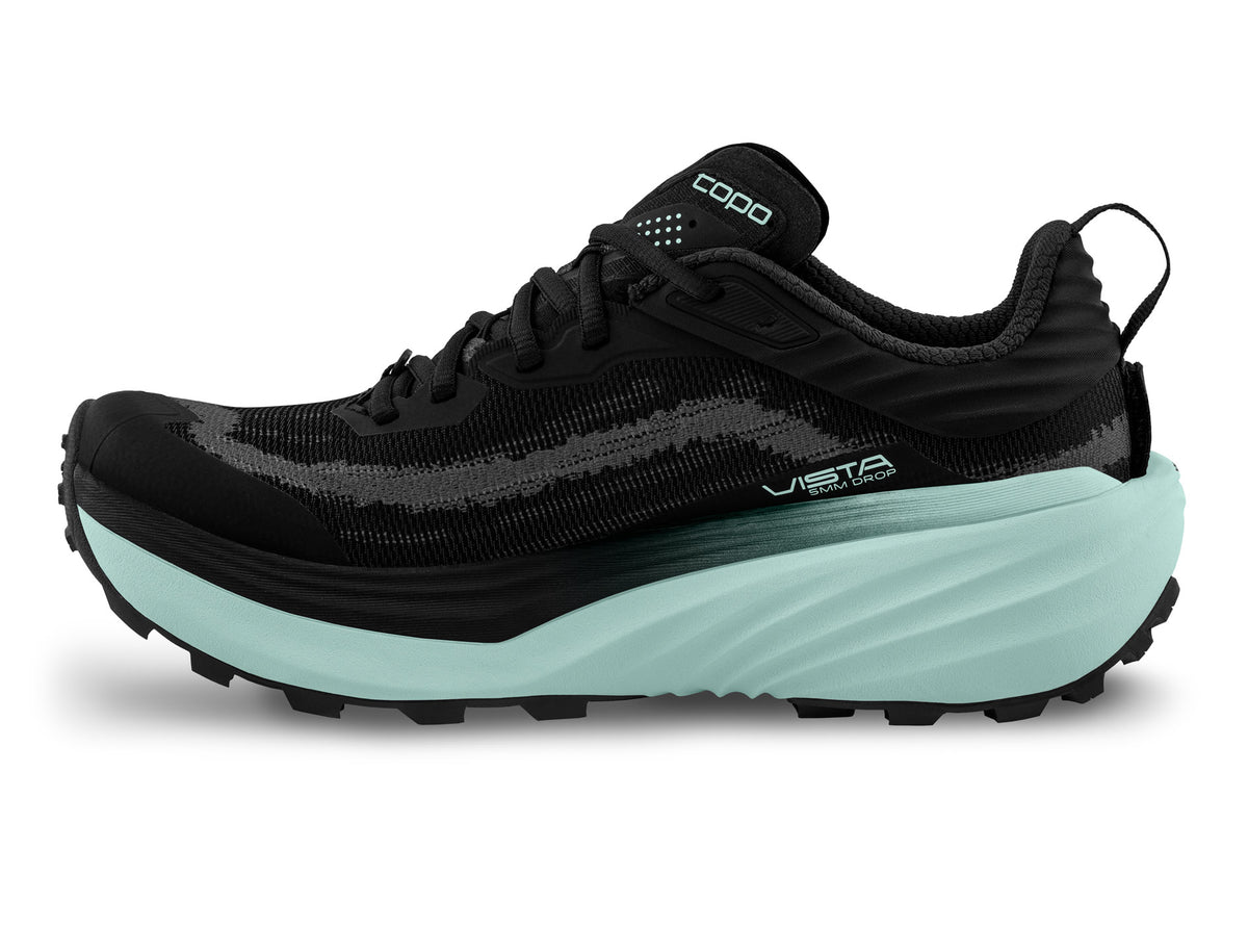 Women's Topo Vista. Black upper. Green midsole. Medial view.
