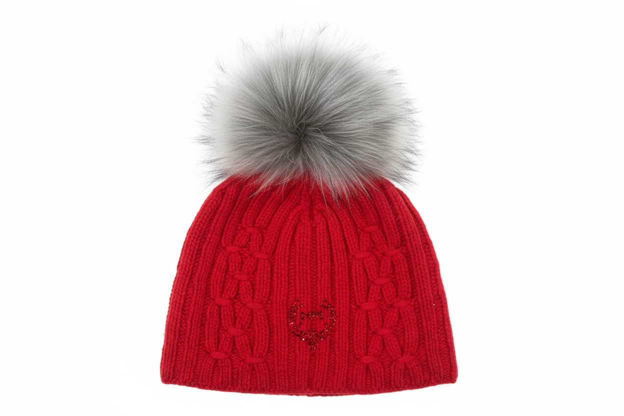 A red cashmere cable knit hat with a detachable gray fur pompom on top.