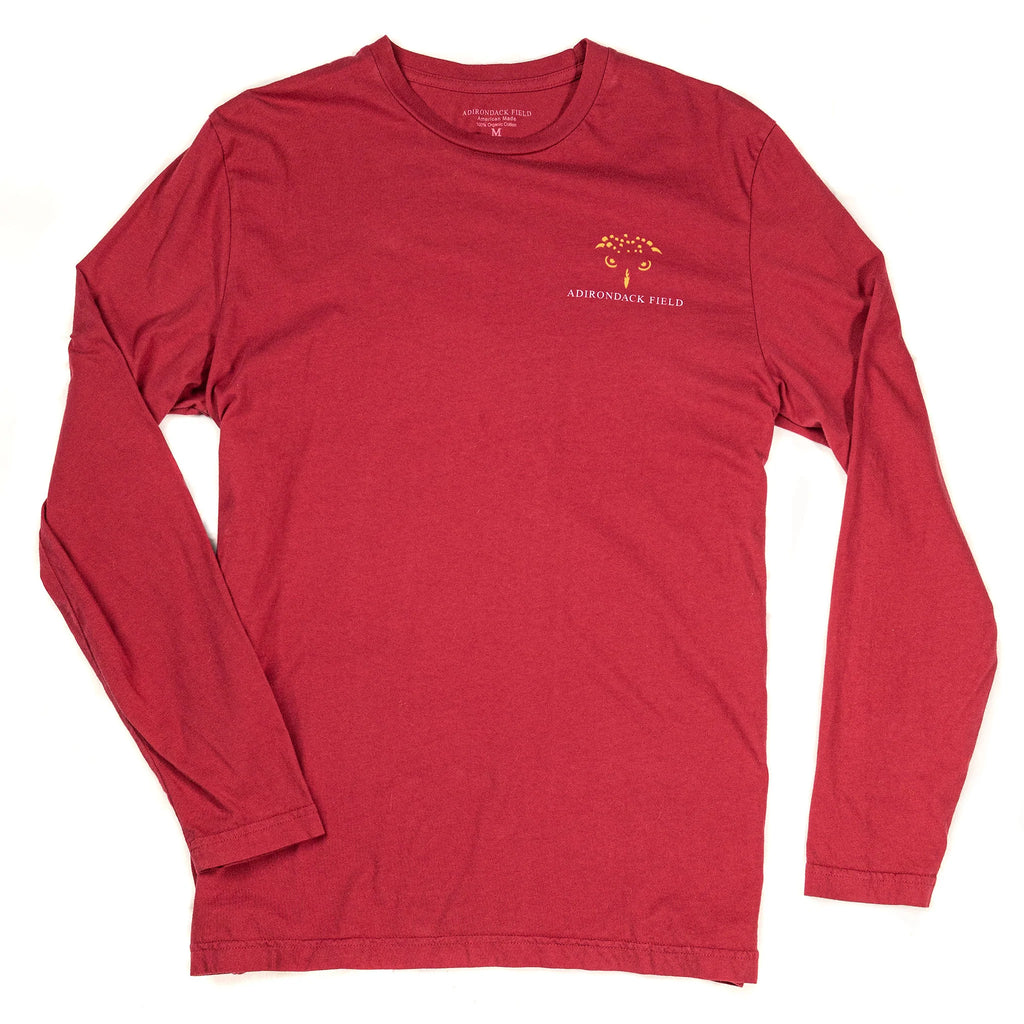 front of a red long-sleeve tee shirt with a yellow outline of an owl's face over the heart and the text "adirondack field"